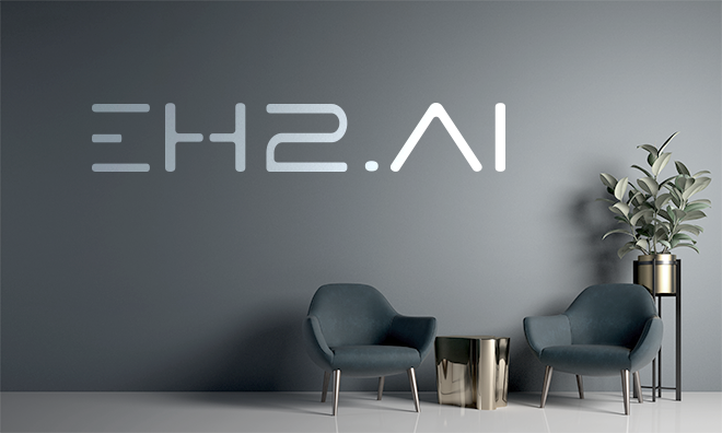 Minimalist grey office interior with EH2.AI brand signage and a simple desk holding a small potted plant